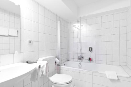 霍根海姆莫托杜姆酒店的白色的浴室设有卫生间和浴缸。