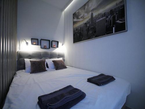 斯维诺乌伊希切4UApart-Apartment studio Platan New York的卧室配有白色床和2条黑色毛巾