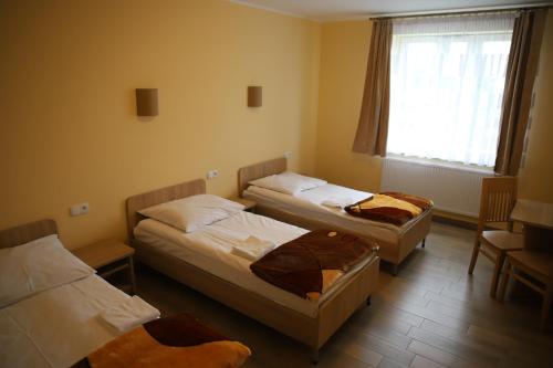 Licheń StaryDom Pielgrzyma BETLEJEM的带三张床和窗户的客房
