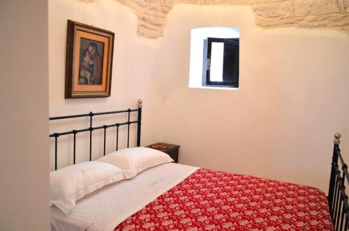 阿尔贝罗贝洛 阿尔贝罗贝洛特鲁利度假屋的一间卧室配有一张带红色毯子的床