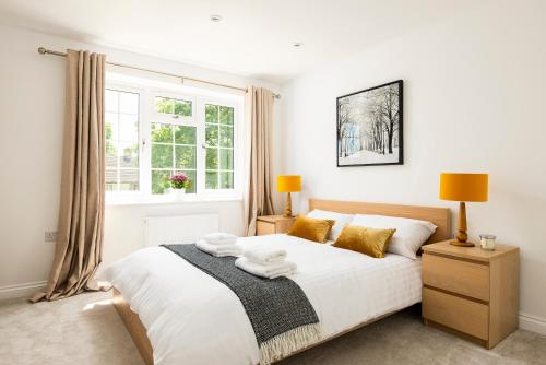 布拉克内尔2 bed house close to Town Centre的卧室配有一张大白色床和窗户
