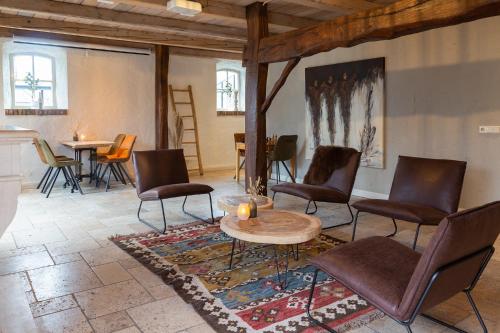 Volkel布拉班特斯胡韦酒店的客厅配有椅子、桌子和桌子
