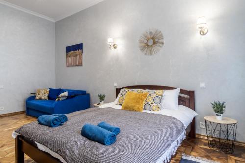 利沃夫Райська Насолода的一间卧室配有一张床和一张蓝色的沙发