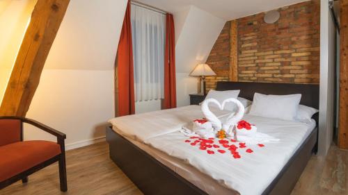 因特拉肯Swiss Inn & Apartments的一间卧室配有一张带两个天鹅和玫瑰的床