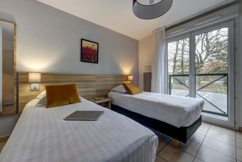 迪沃讷莱班珍妮图德罗勒杜派克公寓式酒店的酒店客房设有两张床和窗户。