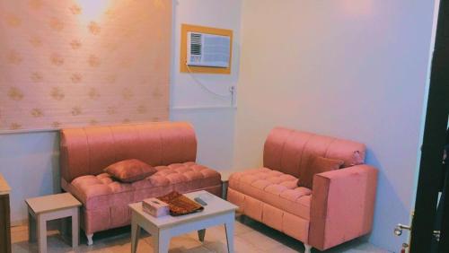 哈费尔巴廷Al Beagy Furnished Units的客厅配有2张粉红色的沙发和1张桌子