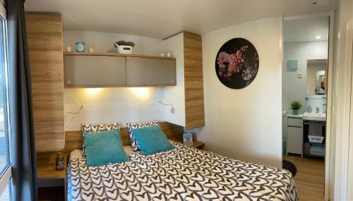 罗维尼Mobile Home DIVINA Camp Porton Biondi的一间卧室配有一张带两个蓝色枕头的床