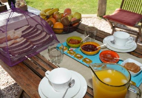 拉帕洛马La Maison Suites & Gastronomía的一张带食物和一碗水果的野餐桌