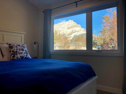 班夫山景住宿加早餐旅馆的一间卧室设有蓝色的床和窗户。