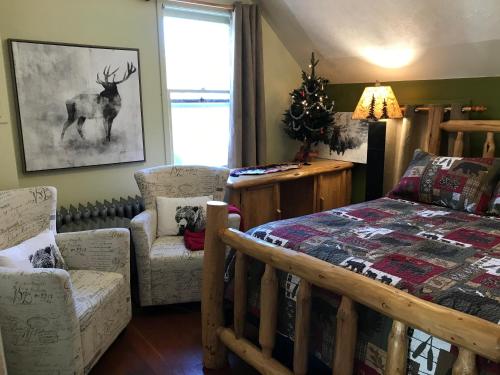 班夫住宿加早餐假日旅馆的一间卧室配有床和椅子以及圣诞树