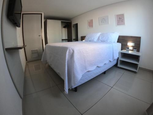 若昂佩索阿Imperial Flat的卧室配有白色的床和电视。