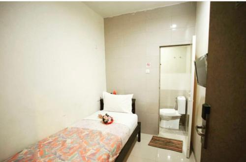 棉兰Permata Inn的一间小卧室,配有一张床和一个卫生间
