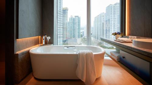 釜山Signiel Busan的带浴缸、水槽和窗户的浴室