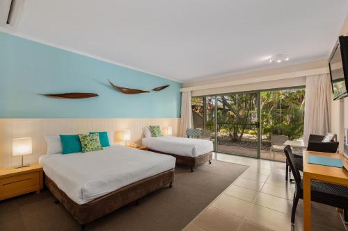 巴利纳Ballina Beach Resort的酒店客房配有两张床、一张书桌和一张书桌