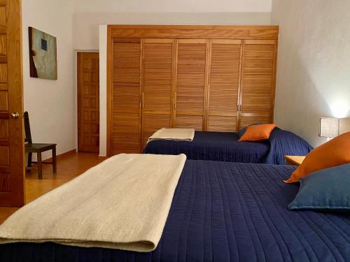 瓜纳华托La Casa de la Glorieta的一间卧室配有两张带蓝色床单和橙色枕头的床