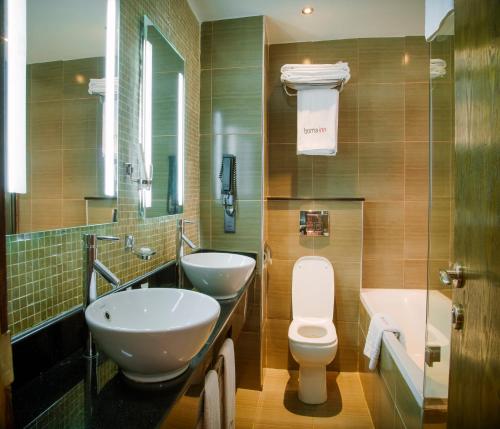 埃尔多雷特埃尔多雷特博马酒店的浴室配有2个盥洗盆、卫生间和浴缸。