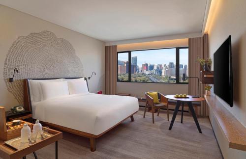 北京北京首北兆龙饭店的酒店客房配有一张床、一张桌子和一张桌子。