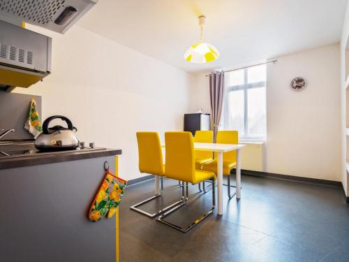 乌斯特龙艾勒梅尔普兰厄特酒店的厨房配有桌子和黄色椅子