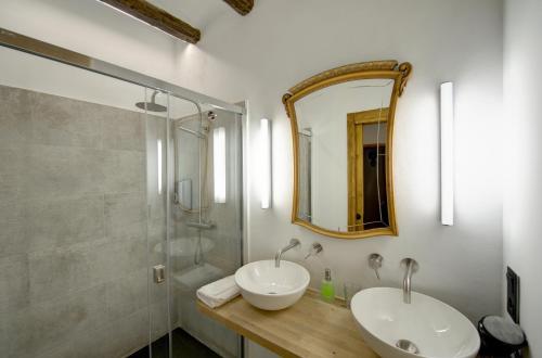巴拉格尔Lo Palauet de la Muralla的浴室设有2个盥洗盆、淋浴和镜子。