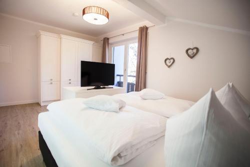 加尔米施-帕滕基兴Olympia的一间卧室配有两张床和一台平面电视