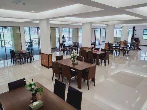 Kampong Seberang TimorTEMU PRIMULA的用餐室设有桌椅和窗户。
