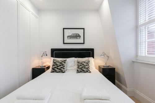 伦敦Urban Chic - Shaftesbury的白色卧室,配有一张带2个床头柜的大床