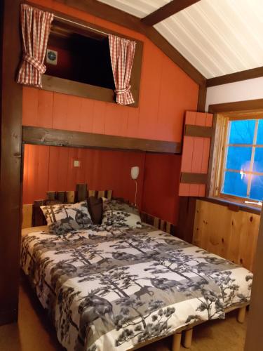 KullenMieps Huset Dalarna Holiday的一间设有床铺的卧室,位于一个红色墙壁的房间