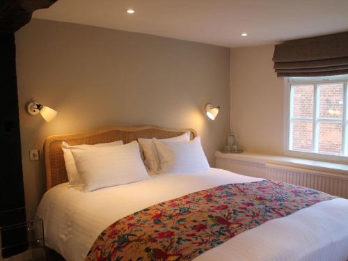 拉伊The Ship Inn的卧室配有一张带白色床单和枕头的大床。