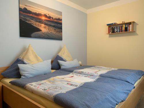 朗格奥Haus Nordland的卧室内的一张带蓝色床单和枕头的床