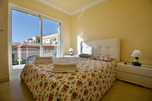 马斯帕洛马斯洛维斯别墅酒店的一间卧室设有一张床和一个大窗户