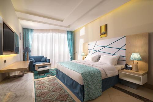 赫尔格达Gravity Hotel & Aqua Park Sahl Hasheesh Families and Couples Only的酒店客房,配有一张床和一张蓝色椅子