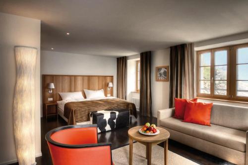 卢塞恩皮拉图库姆酒店的酒店客房配有床、沙发和桌子。