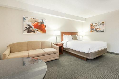 布谢维尔迎宾酒店的酒店客房,配有床和沙发