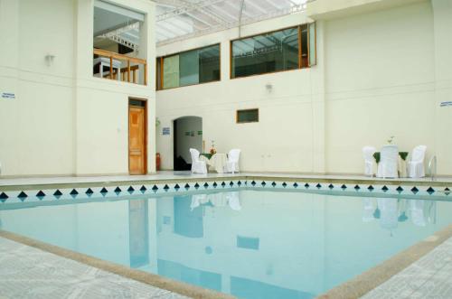 杜伊塔马Hotel Dinastia Real的白色墙壁的建筑中的游泳池