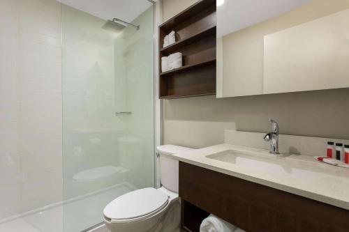 蒙特朗布朗Microtel Inn & Suites by Wyndham Mont Tremblant的浴室配有卫生间、盥洗盆和淋浴。