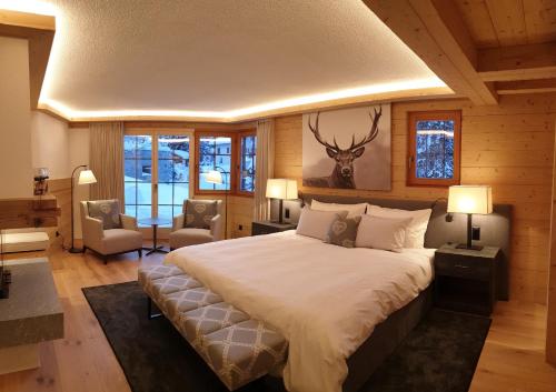 达沃斯Chalet Chesa Surlej, Davos的卧室配有一张大床,墙上挂着鹿头