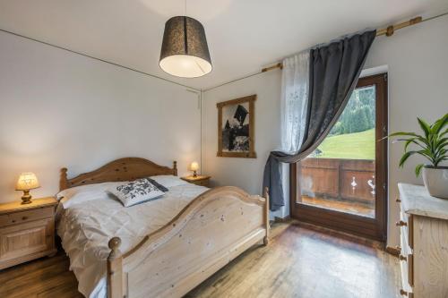 费拉迪普利米罗Agritur Broch的一间卧室设有一张床和一个大窗户
