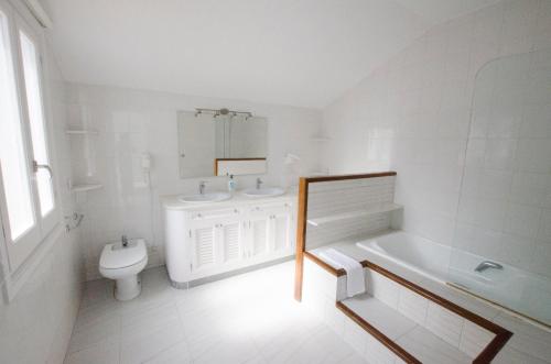 卡拉加尔达纳Villa Serpentona的白色的浴室设有卫生间、水槽和浴缸。