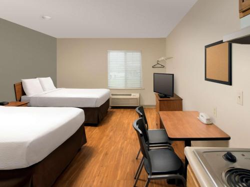 克拉克斯维尔克拉克斯维尔伍德斯普林路易斯维尔酒店的酒店客房设有两张床、一张书桌和一个厨房。