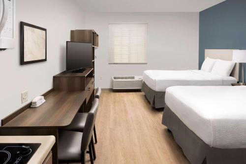 肯代尔WoodSpring Suites Miami Southwest的酒店客房配有两张床和一张书桌