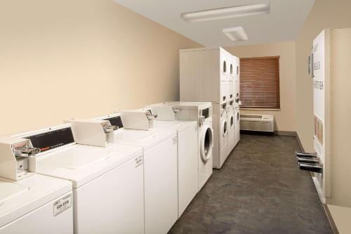 辛普森维尔WoodSpring Suites Greenville Simpsonville的洗衣房配有白色洗衣机和烘干机