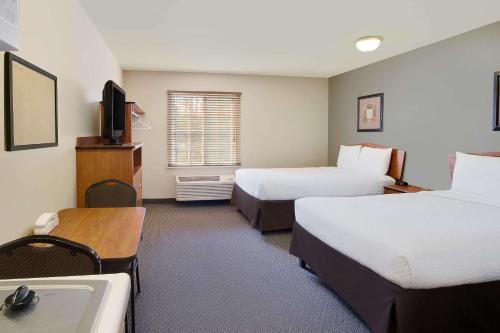 里士满WoodSpring Suites Richmond West I-64的酒店客房设有两张床和盥洗盆