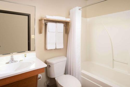 圣安吉洛WoodSpring Suites San Angelo的浴室配有盥洗盆、卫生间和浴缸。