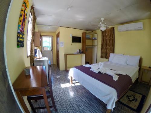 库尔克岛Chila's Accommodations的配有一张床和一张书桌的酒店客房