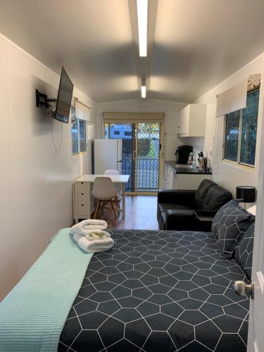 努尔卡巴Wine Country Tourist Park Hunter Valley的一间卧室设有一张床、一间客厅和一间厨房