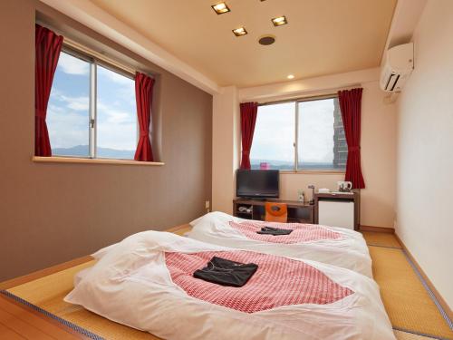 大洲哈塔格桥本酒店的一间设有床铺的卧室,位于带窗户的房间内