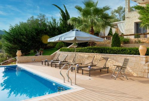 米克罗斯雅洛斯Ionian Diamond Villas的游泳池旁的天井配有椅子和遮阳伞。
