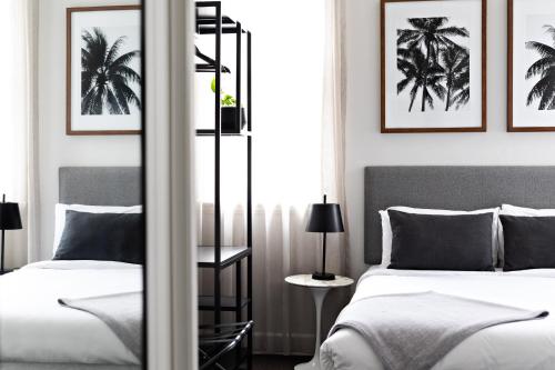 悉尼St Marks Randwick的卧室配有两张挂在墙上的棕榈树床。