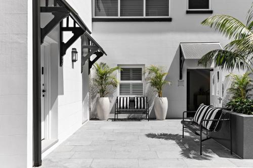 悉尼St Marks Randwick的一座建筑前带两个长椅的庭院
