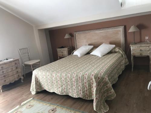 Colmenar del Arroyo阿不思阿尔比乡间农舍的一间卧室配有一张带2个床头柜和2张桌子的床